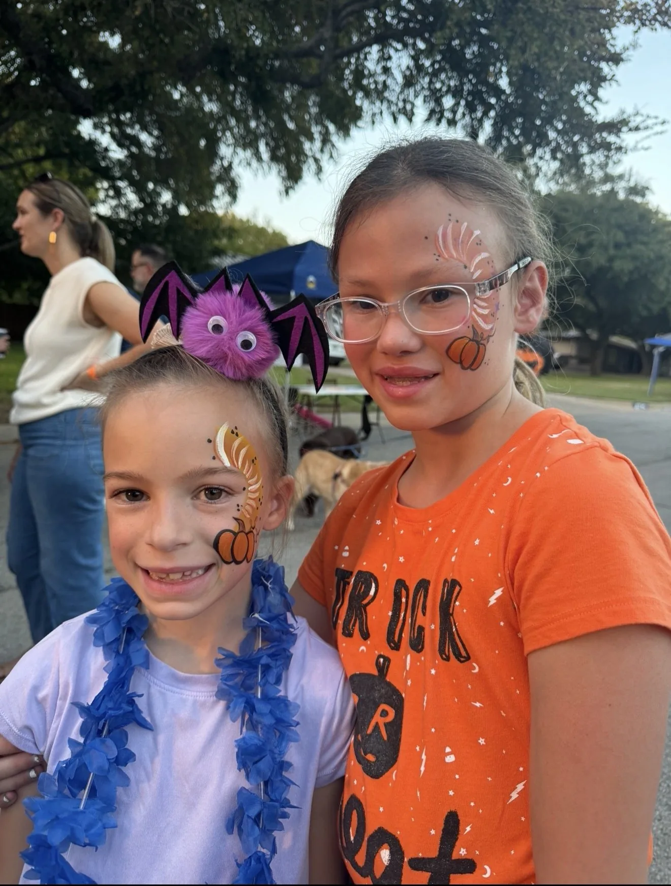 Children showing colorful fall and Halloween face painting designs
