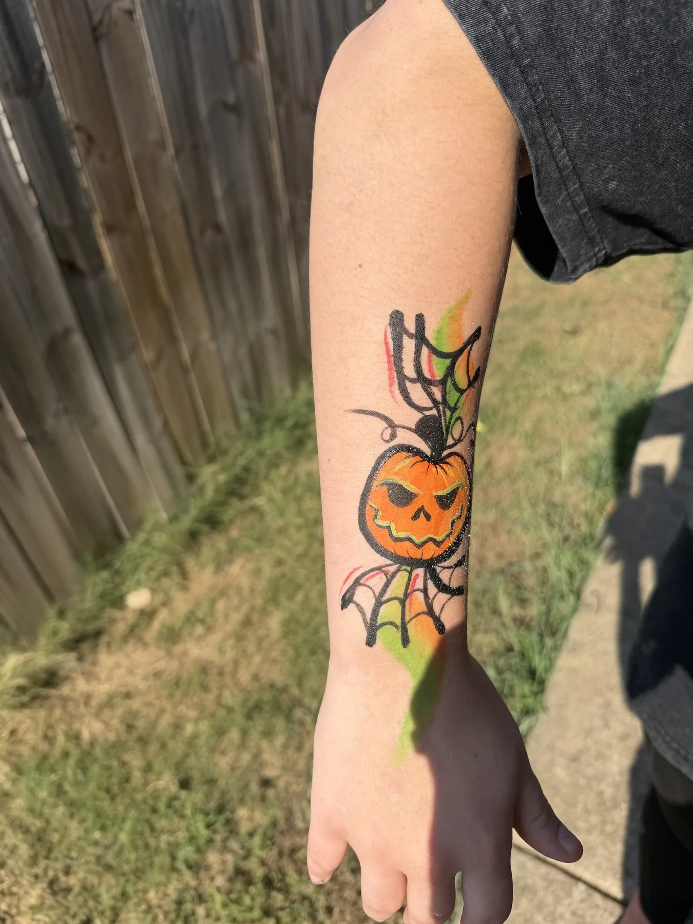 Jack-o-lantern and spiderweb arm painting for Halloween