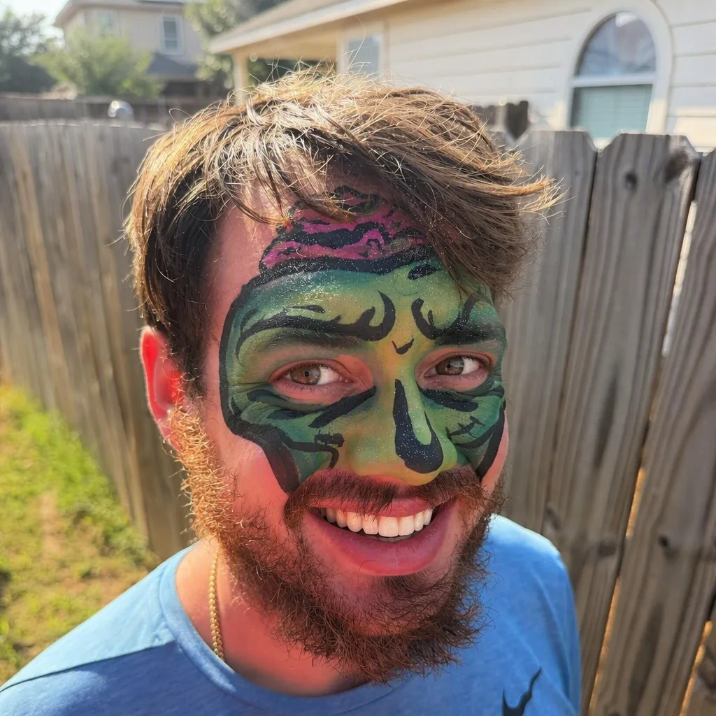 Adult wearing detailed green zombie face painting for Halloween